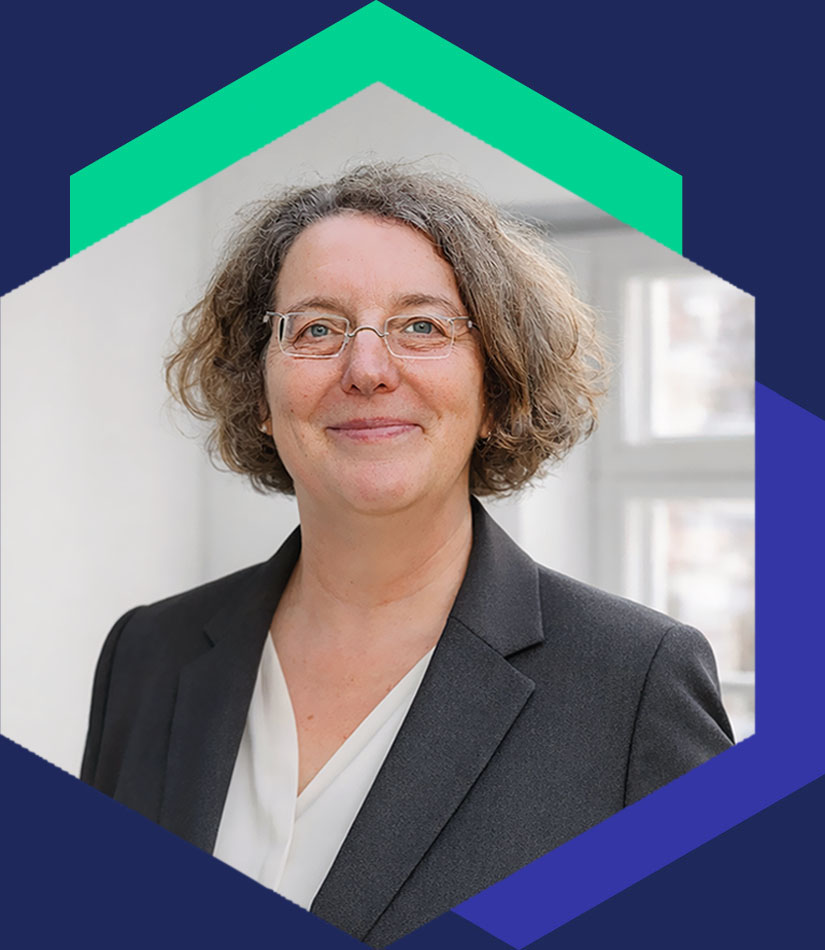 Porträt von Anke Krey mit Brille in einem dunklen Blazer und einer hellen Bluse vor einem hellen Hintergrund, Senior Beraterin bei WeichertMehner