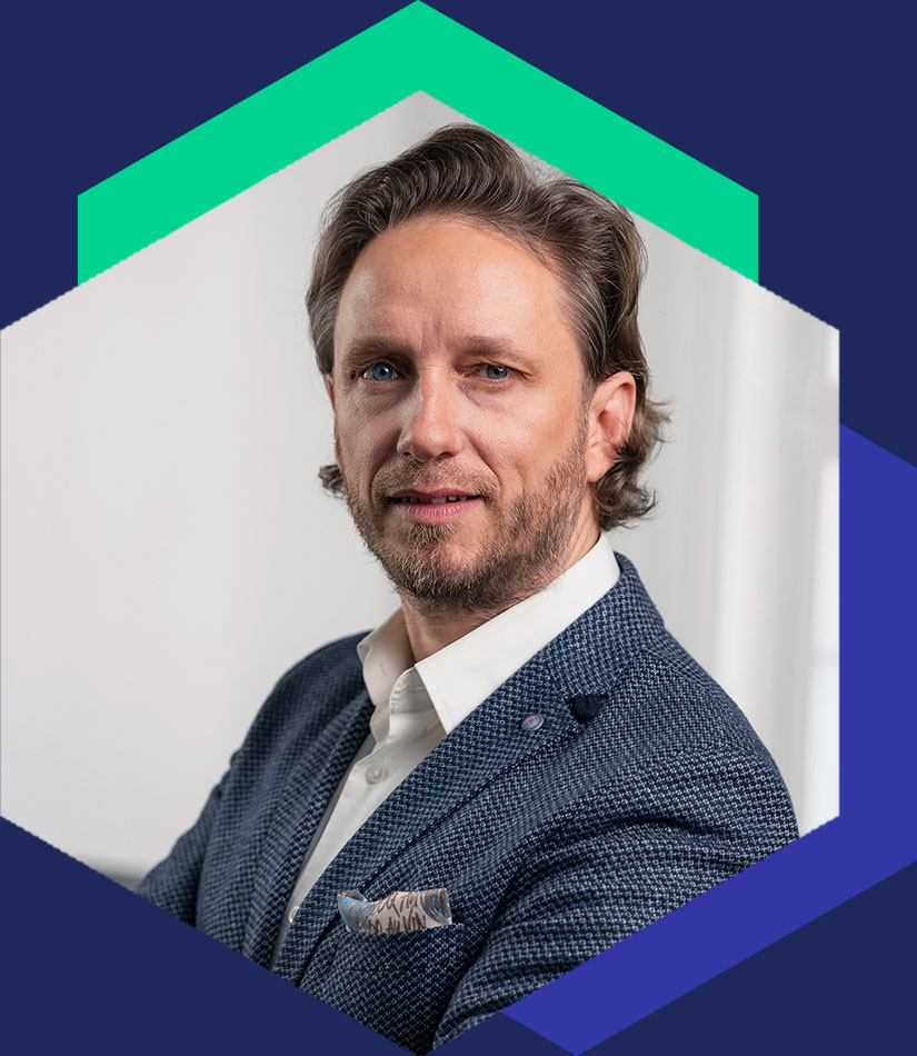 Dr. Erik Fritzsche im blauen Sakko mit Einstecktuch, grafisch eingerahmt in einem Hexagon-Design, Senior Berater für strategische Kommunikation und Krisenmanagement bei WeichertMehner