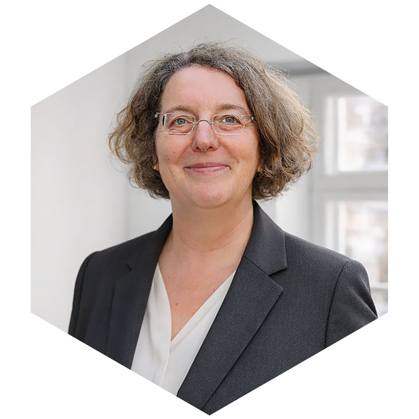 Porträt von Anke Krey mit Brille in einem dunklen Blazer und einer hellen Bluse vor einem hellen Hintergrund, Senior Beraterin bei WeichertMehner