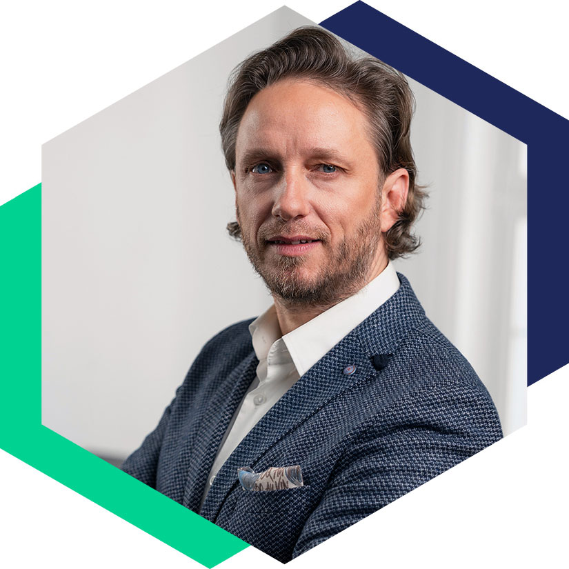 Dr. Erik Fritzsche im blauen Sakko mit Einstecktuch, grafisch eingerahmt in einem Hexagon-Design, Senior Berater für strategische Kommunikation und Krisenmanagement bei WeichertMehner