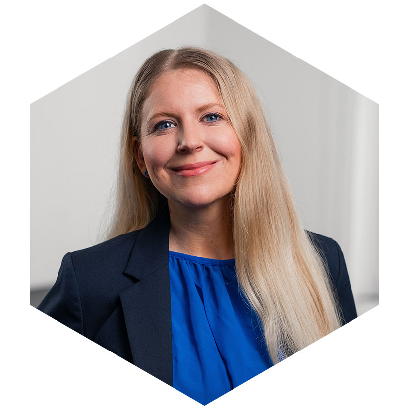 Porträt von Laura Rind-Menzel in einem dunkelblauen Blazer und blauer Bluse, grafisch eingefasst in einem hexagonalen Design-Element, Beraterin für strategische Kommunikation bei WeichertMehner