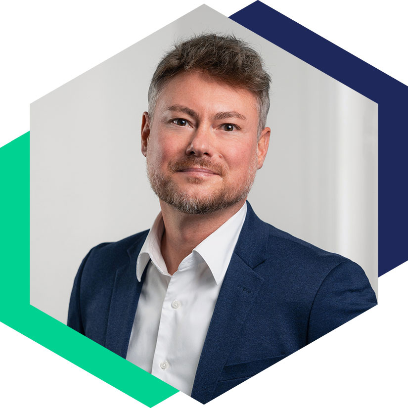 Porträt von Mathias Rentsch m blauen Sakko und weißem Hemd, dargestellt in einem hexagonalen Grafik-Element, Senior Berater für strategische Kommunikation und Krisenberatung bei WeichertMehner